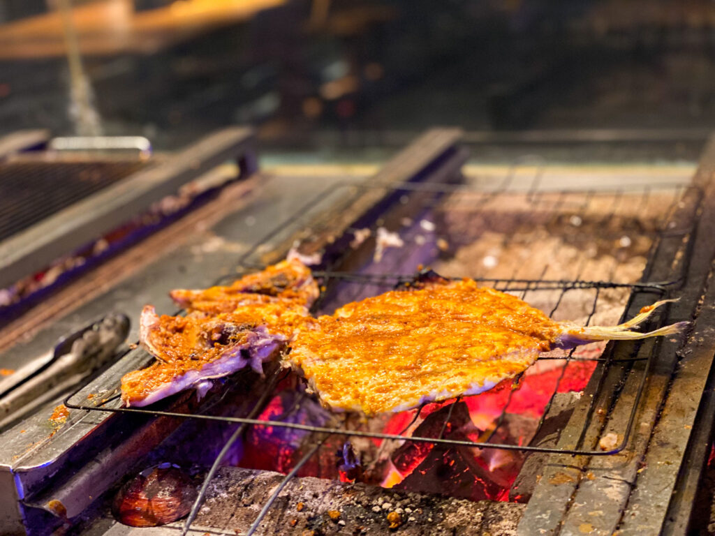 Fresh seafood cooking over golden ambers at Fisherman's Club. Photo: Harmeet Sehgal